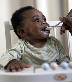 Un bambino che viene nutrito sul seggiolone.