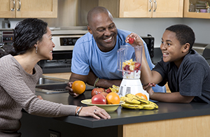 Familie, die Frucht-Smoothies zubereitet.