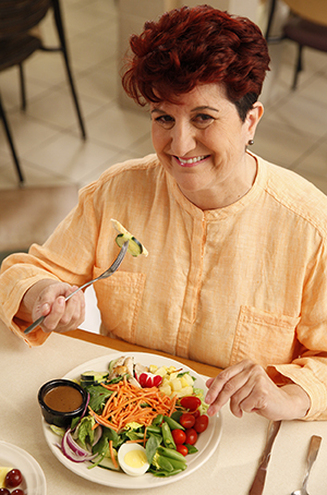 Mulher comendo salada.